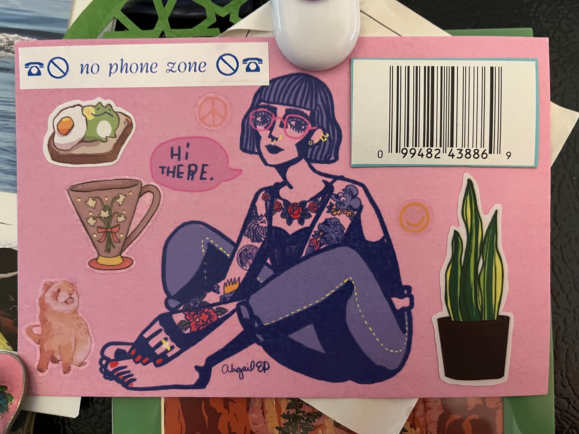 colorful postcard of a tattooed lady with stickers, a barcode, and a label saying "no phone zone" attached
